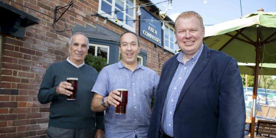 The Christou family and Greene King Pub Partners MD Dan Robinson outside the Axe & Compasses 